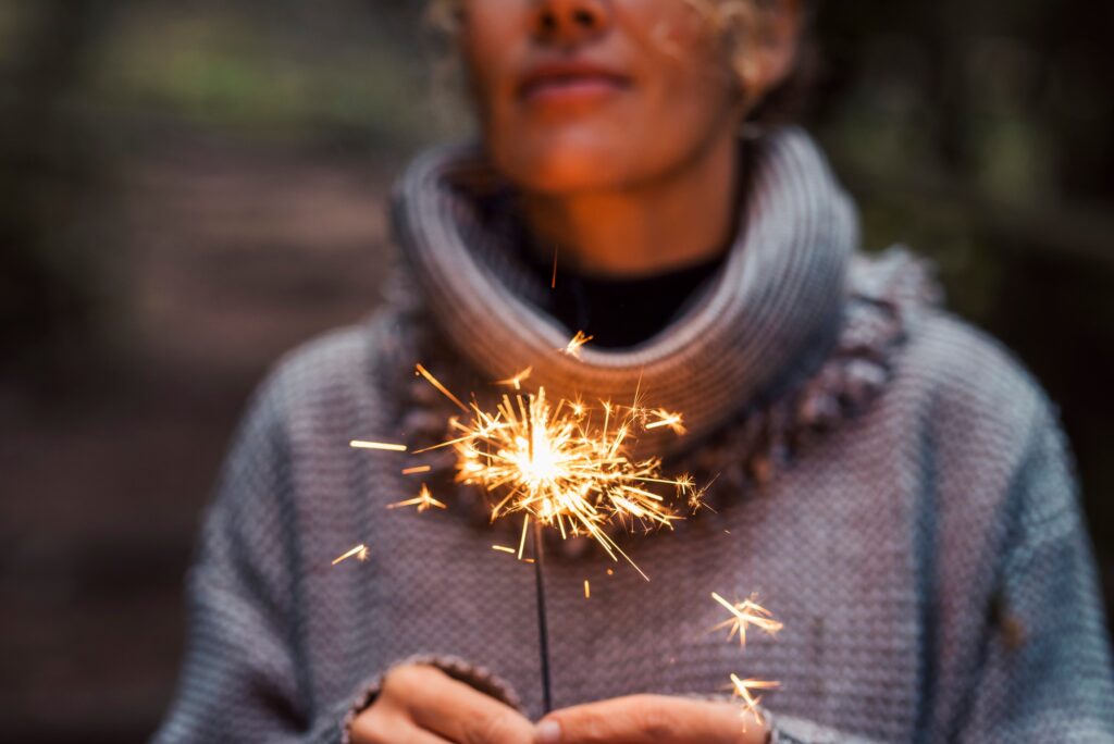 Close up of woman people holding sparkler and celebrate outdoor. New year eve and christmas