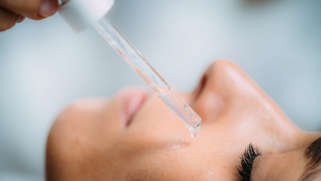 Cosmetician Applying Hyaluronic Acid Serum on Woman’s Face