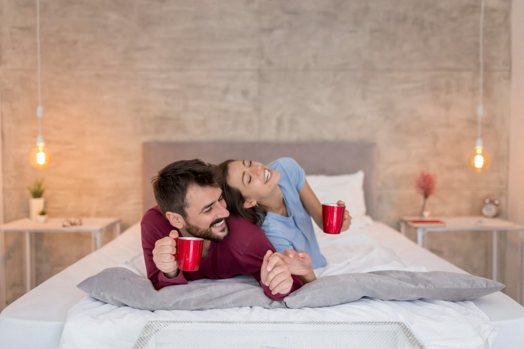 Couple drinking morning coffee in bed