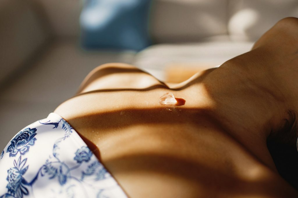 Cropped hoto of ice cube on the girl's body in swimwear