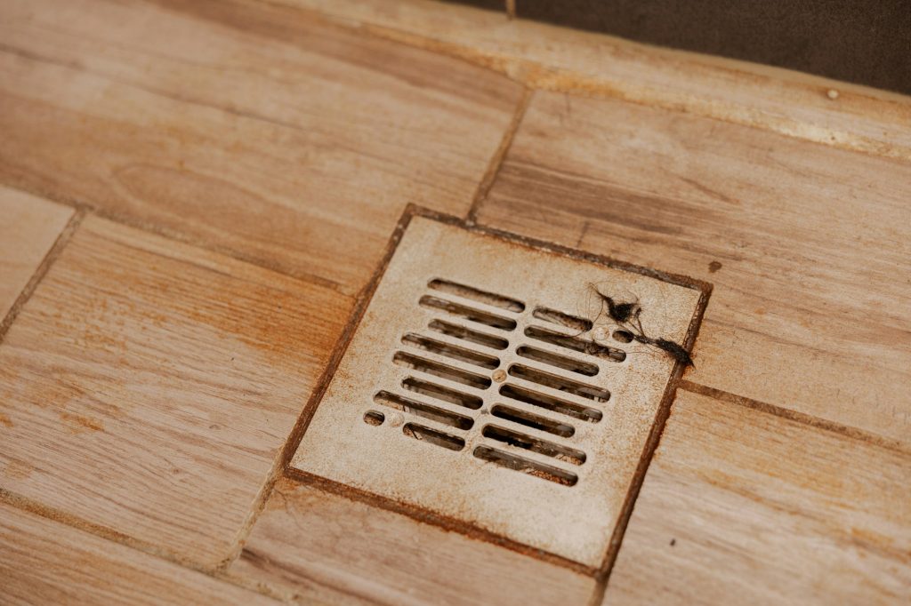Dirty and disgusting shower drain, close up view. Clogged drain with rust stain, hair.