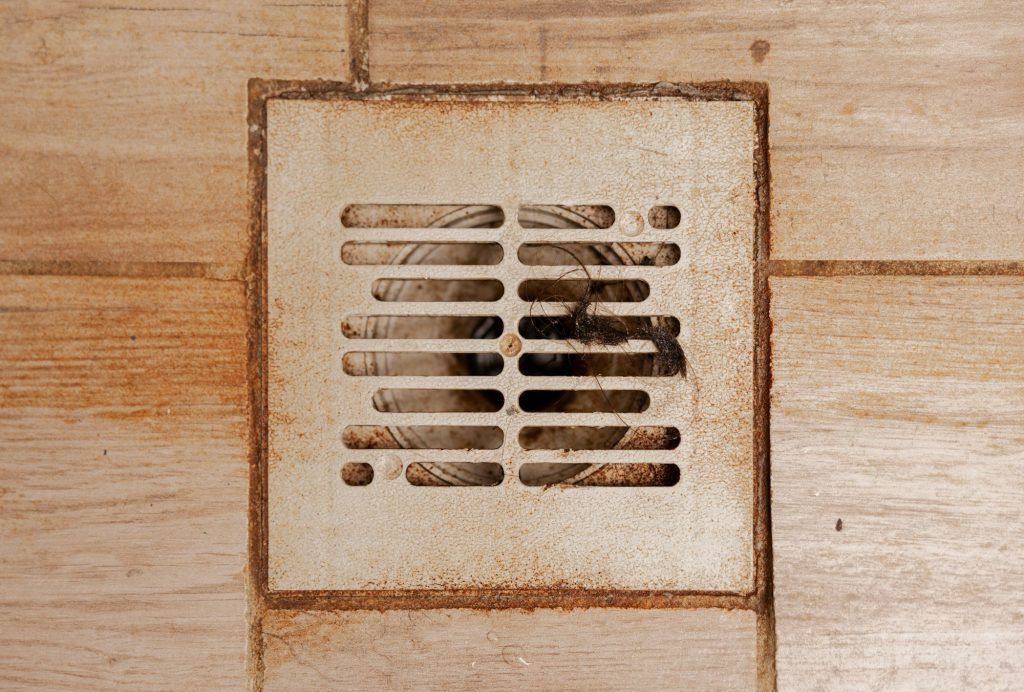 Dirty and disgusting shower drain, close up view. Clogged drain with rust stain, hair.