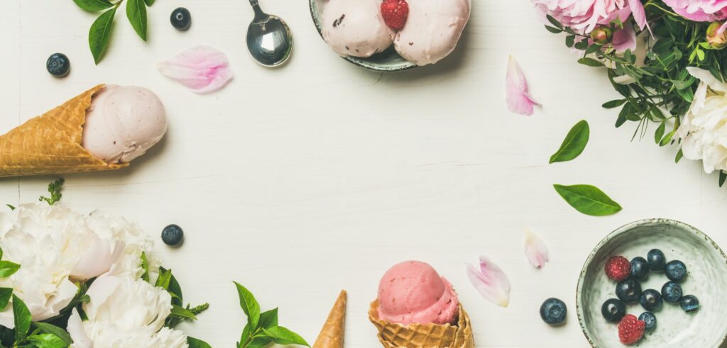 Flat-lay of ice cream scoops and peonies, wide composition