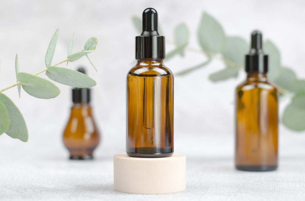 Natural Eucalyptus Oil. Mock up glass bottle and eucalyptus
