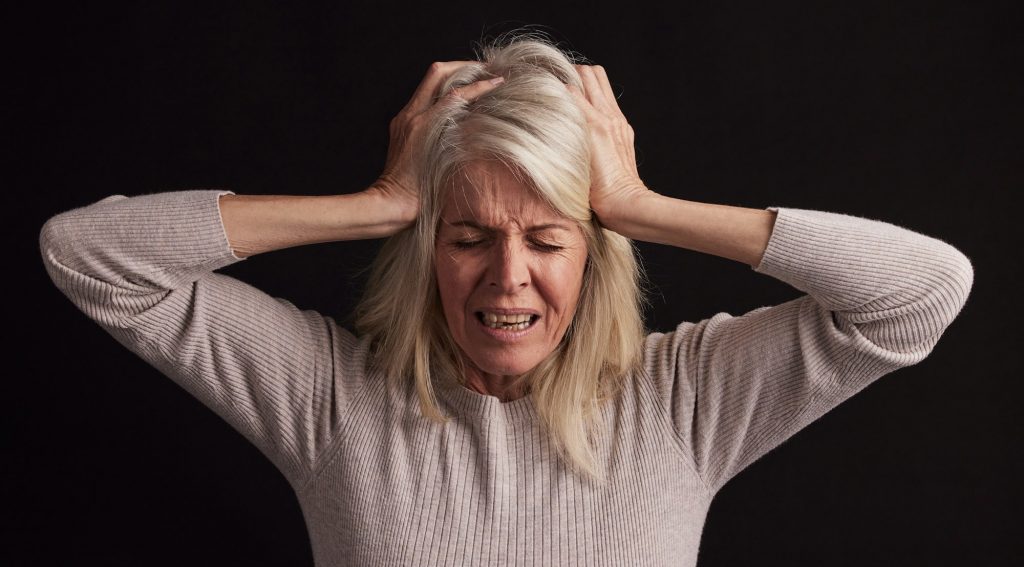Senior woman, stress or anxiety on black background in studio in schizophrenia, bipolar disorder or