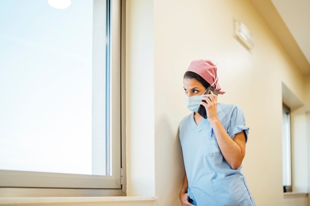 Female doctor surgeon using smart phone.