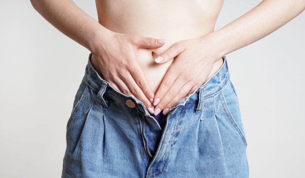woman holding belly with abdominal or period pains