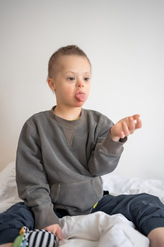 Portrait of playing with toy in home bedroom. Down syndrome and ASD