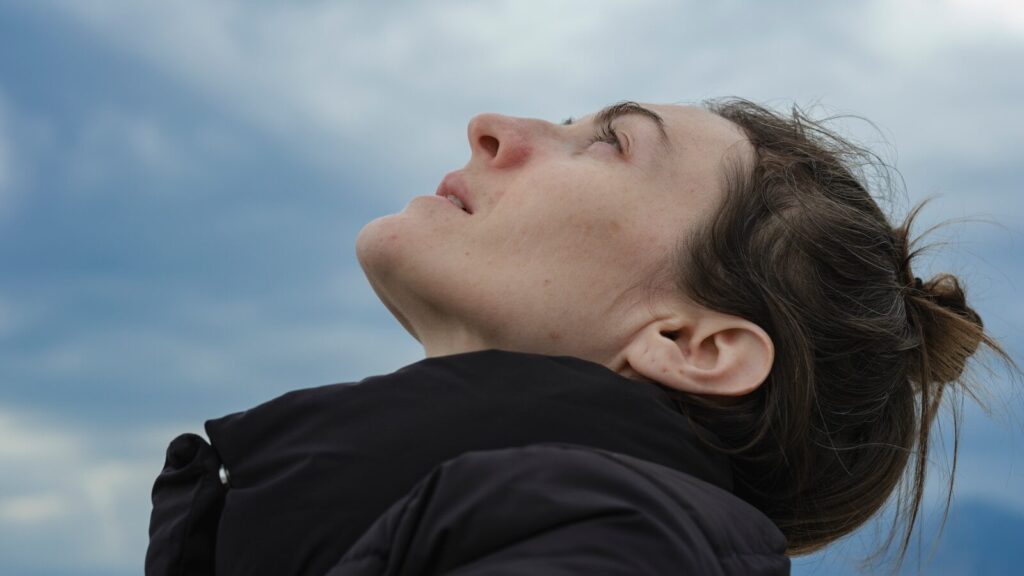 a woman looking up into the sky with her eyes closed