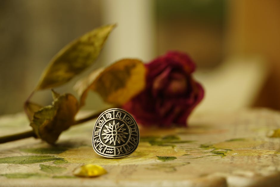 L’horoscope a-t-il une base scientifique ? Une enquête sans filtre Close-up of a zodiac-themed ring with dried flowers in a warm, artistic setting.