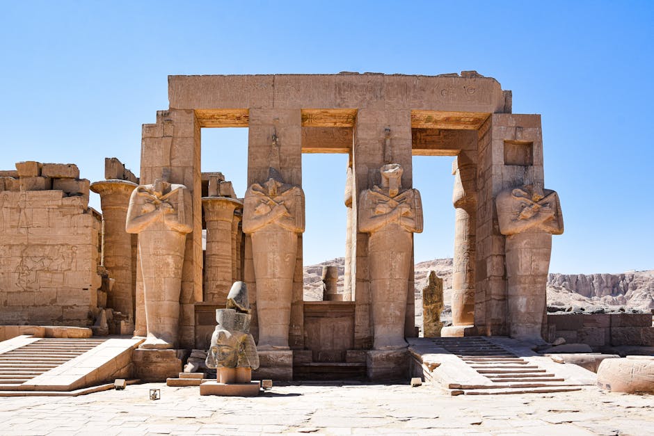 La momie de Ramsès II a-t-elle reçu un vrai passeport français ? Le vrai du faux Explore the grand ancient statues and ruins of the Ramesseum in Luxor, Egypt, under a clear blue sky.