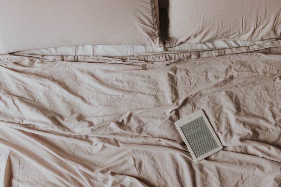 Person reading on an e-reader in a dim bedroom