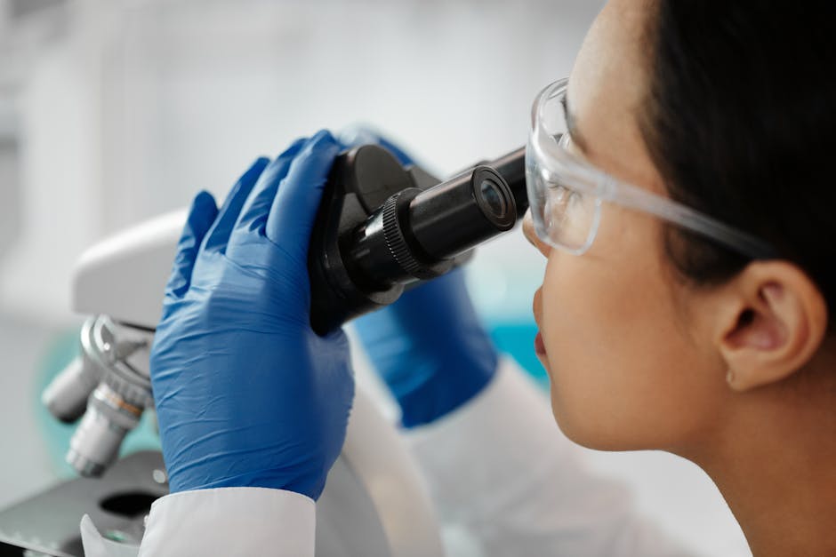 Scientist examining glass structure under microscope