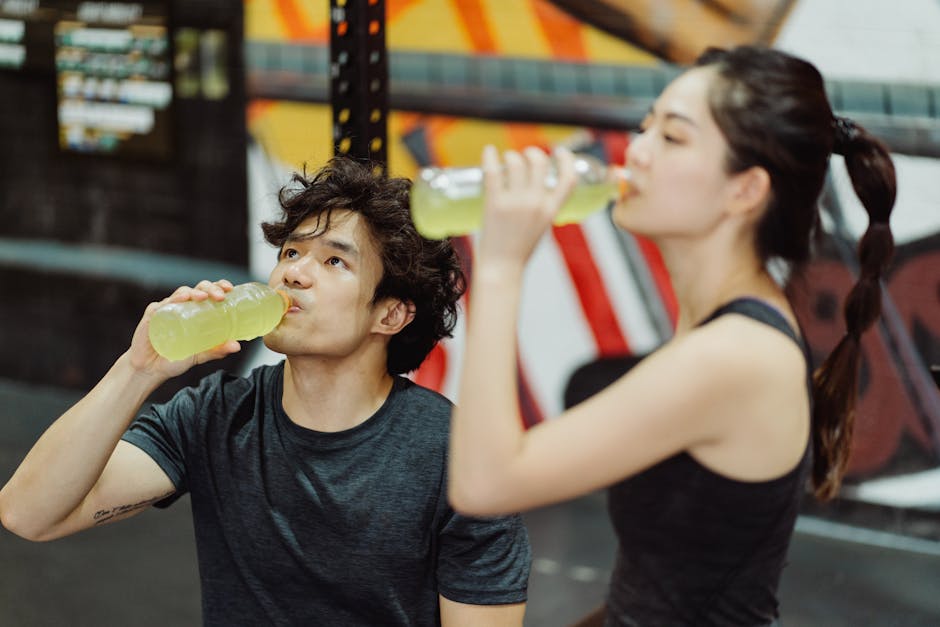 Person drinking green tea before a workout in a bright gym