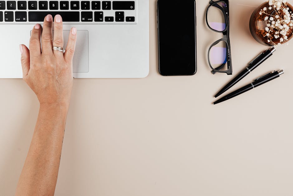 Person writing left-handed at a desk with ergonomic tools