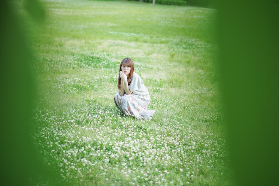 Person searching for clovers in a grassy field