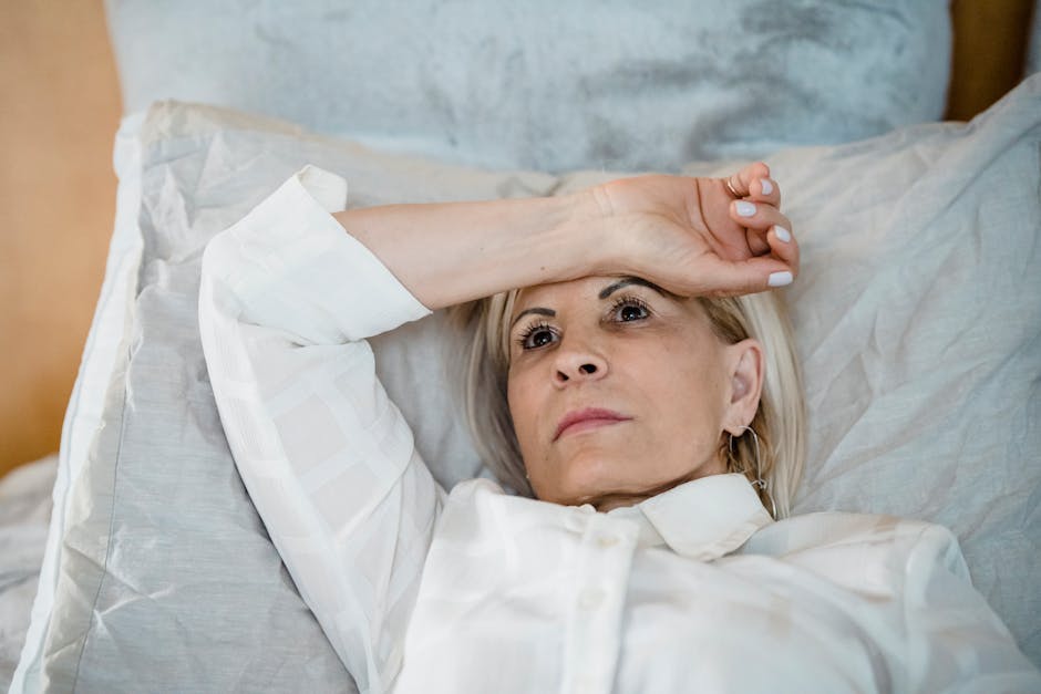 Person resting with hand on forehead in a warm environment