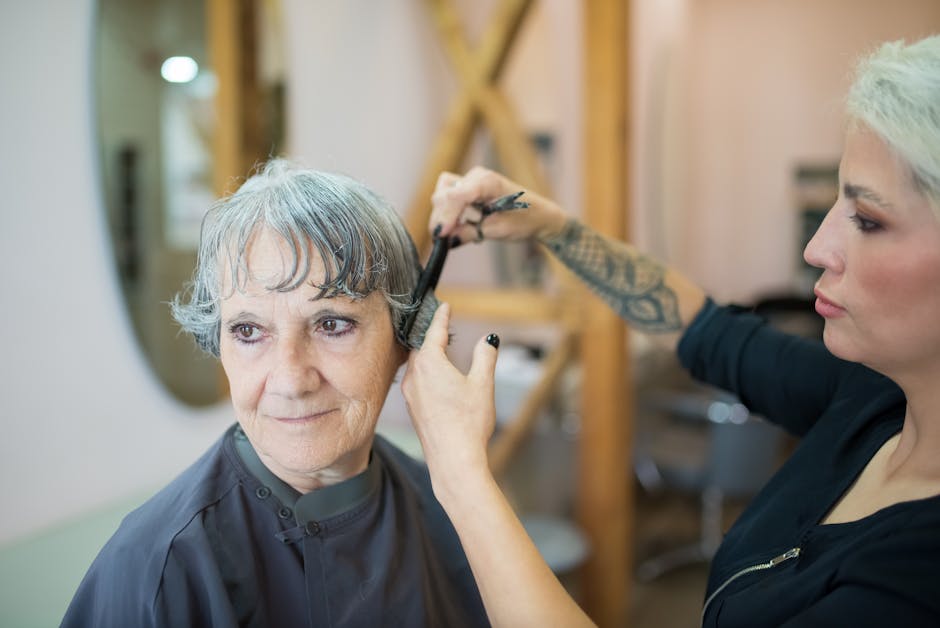 Coiffeur en train de couper les cheveux d'une cliente dans un salon