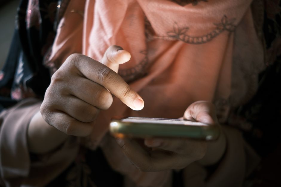 Person holding a smartphone with wireless signal concept