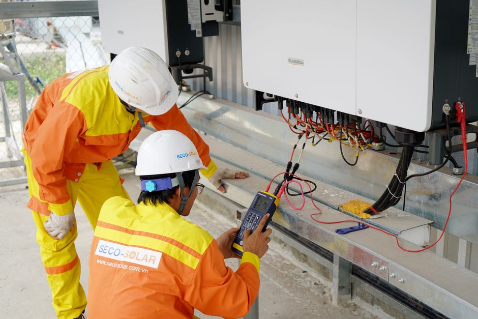 L’énergie solaire est-elle vraiment rentable dans les pays du Nord ? Chiffres, cas concrets et angles morts Two electrical engineers installing and testing solar power systems wearing safety gear at a construction site.