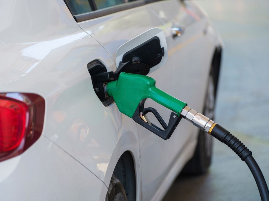 Driver refueling a car at a gas station pump