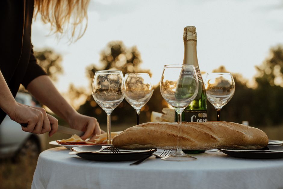 Person eating cheese at dinner table with a late evening meal