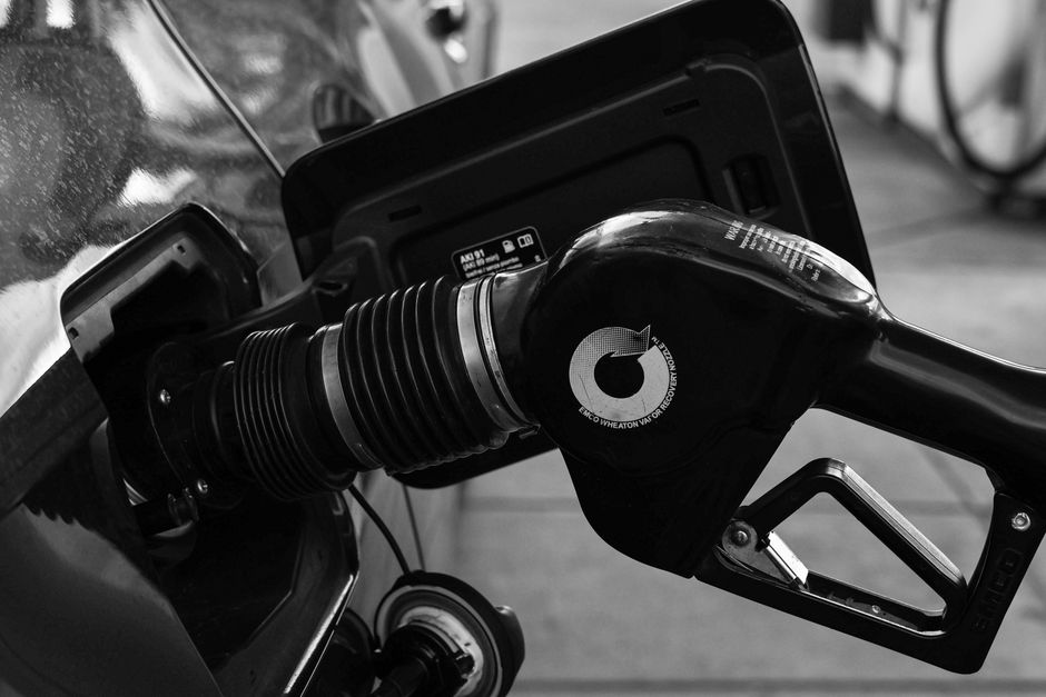 Close-up of fuel nozzle and vapor at a gas station