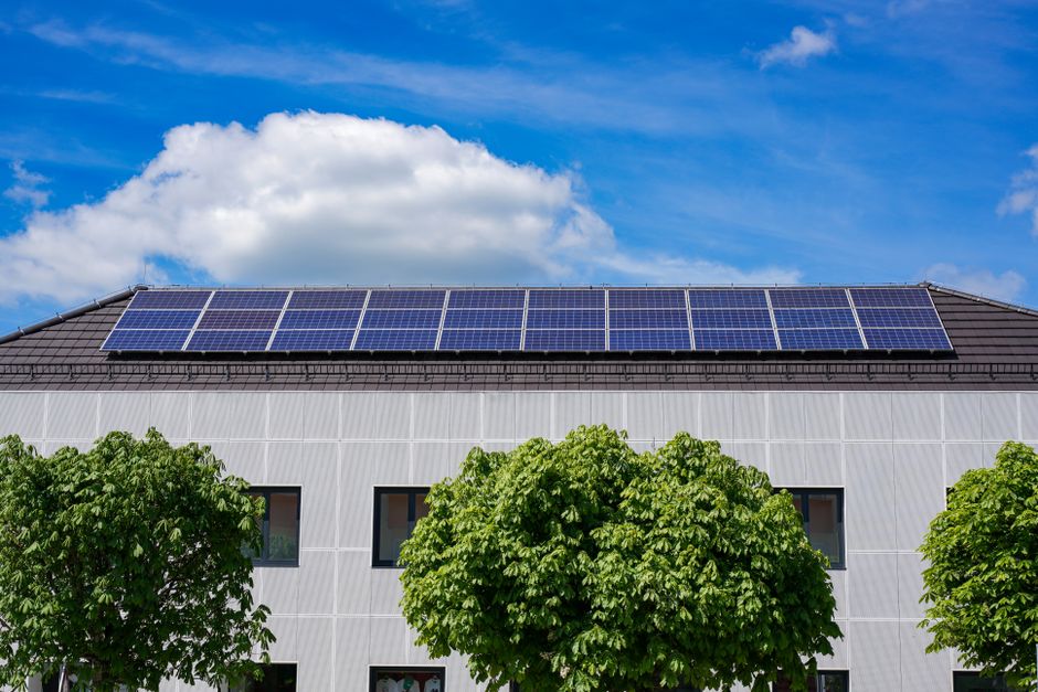 Solar panels on a rooftop under a cloudy northern sky