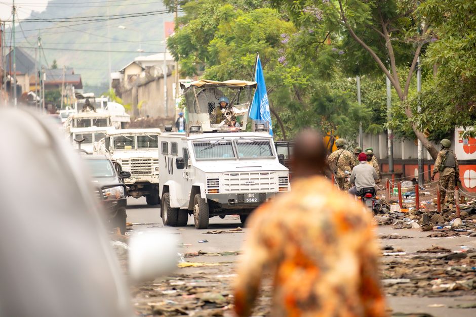 Les pièces de monnaie jetées du haut d’un gratte-ciel peuvent-elles tuer ? UN armored vehicles and peacekeepers patrol a busy urban street.