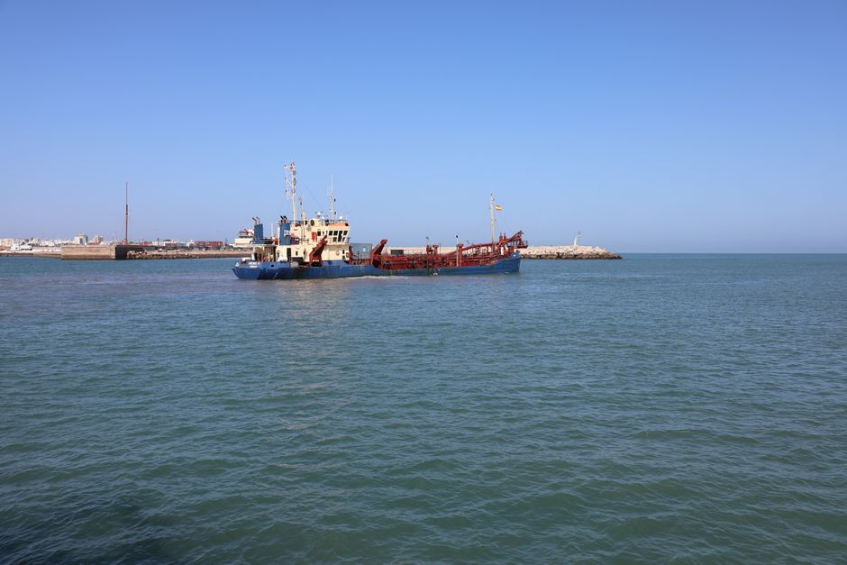 Sand dredging ship at sea near coastline