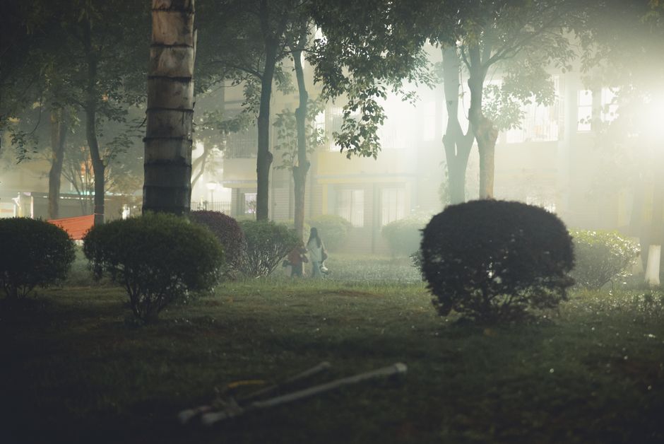 Person applying mosquito repellent outdoors at dusk