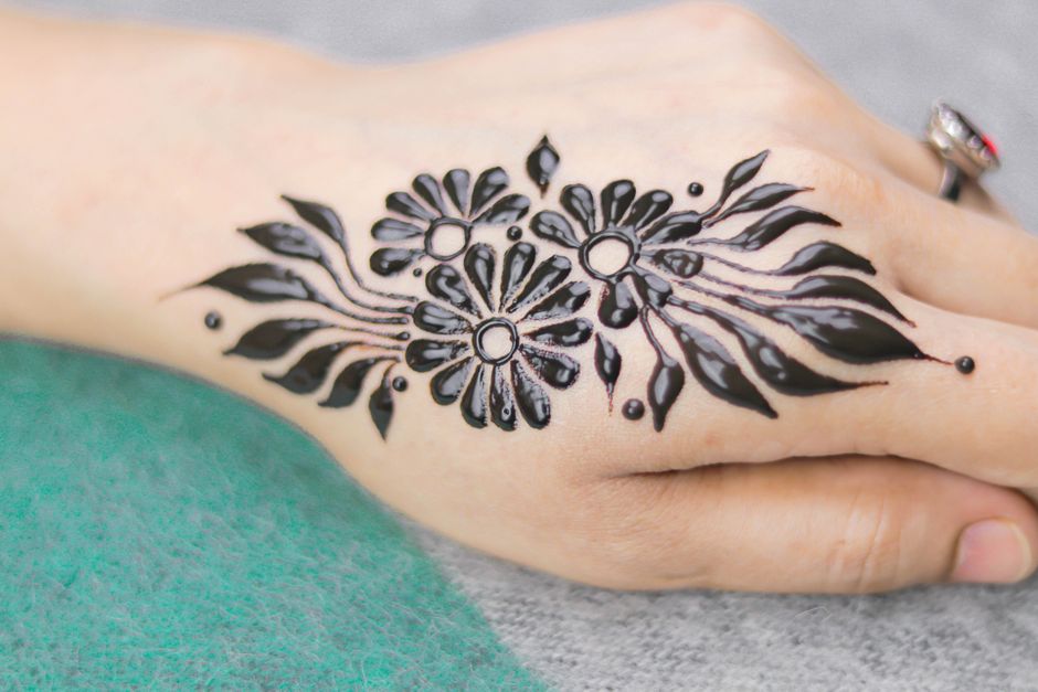 Temporary henna tattoo on skin with brown-orange floral design