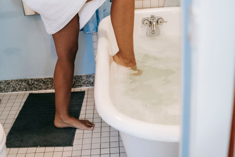 Sèche-cheveux près d'une baignoire dans une salle de bains humide