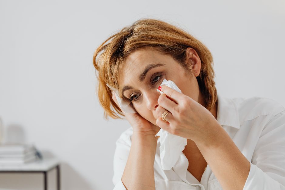Le syndrome de la page blanche est-il un vrai trouble psychologique ? Ce que disent les psys et les chercheurs Portrait of woman holding tissue, expressing emotion, wiping tears.