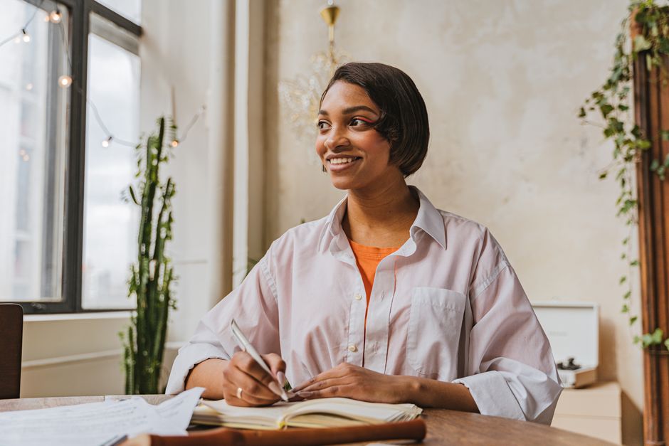 Focused person writing in a notebook in a calm cafe environment