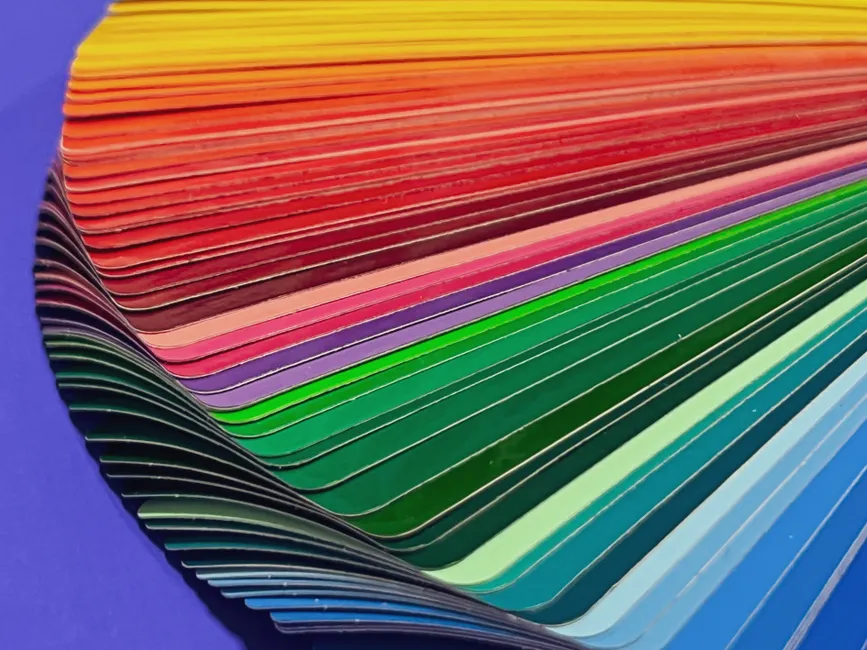 Les couleurs ont-elles vraiment un effet sur notre humeur? A vibrant stack of color swatches in a rainbow spectrum for design inspiration.