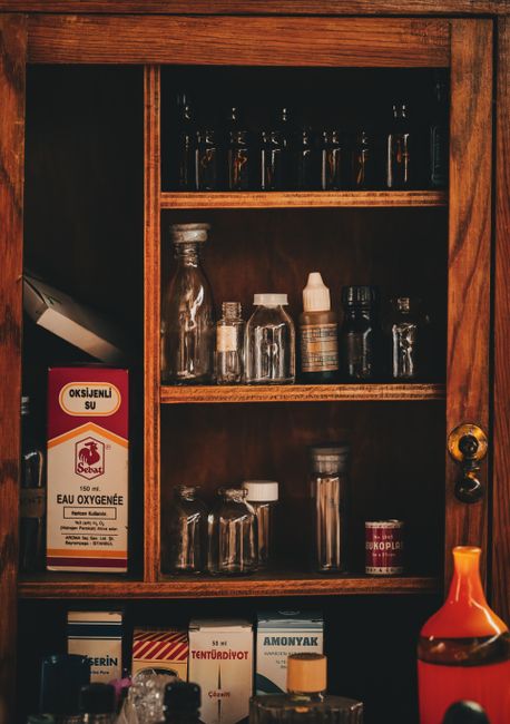 A wooden cabinet filled with vintage medicine bottles and vials in Ankara, Türkiye.