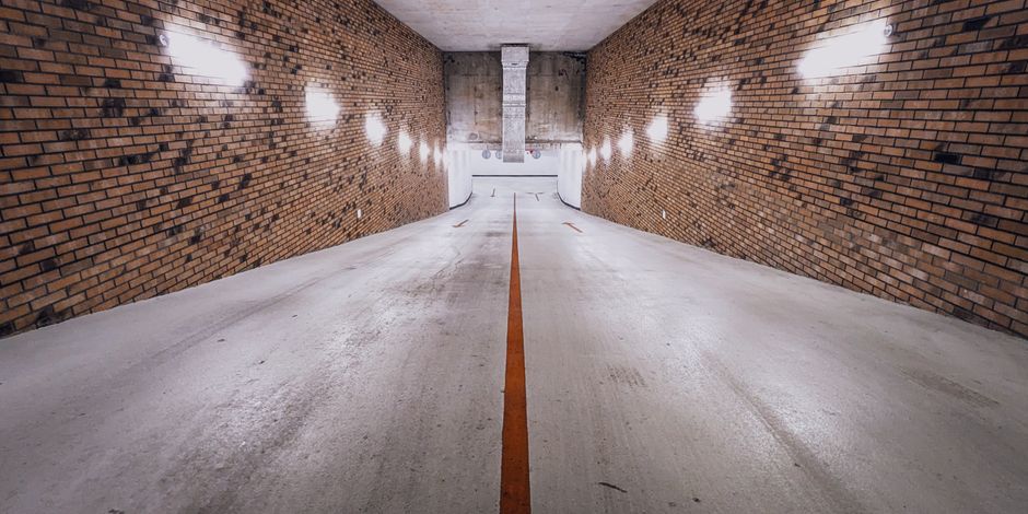 Les tremblements de terre peuvent-ils être provoqués par l’homme? An underground brick-walled ramp with dim lighting and a single yellow line, creating a cinematic feel.