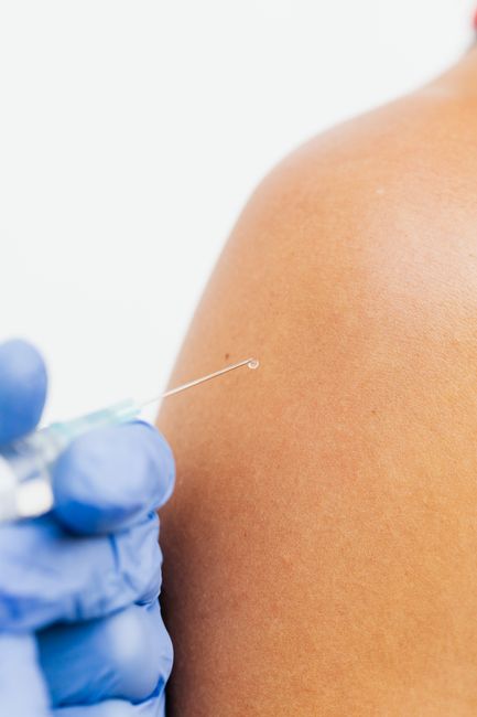 Detail shot of a healthcare professional administering a vaccine injection.