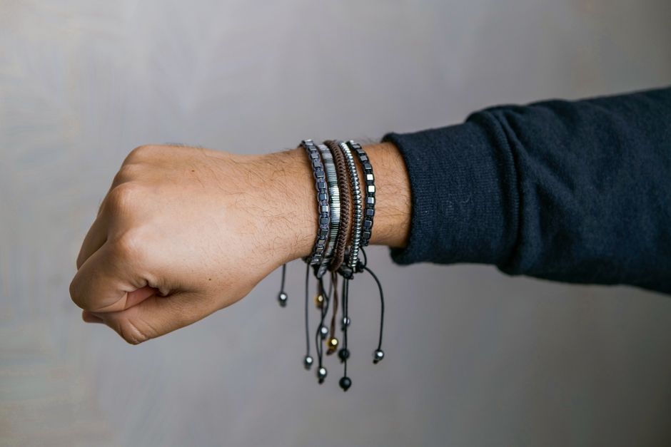 Les bracelets magnétiques soulagent-ils vraiment les douleurs? Stylish collection of men's bracelets elegantly displayed on a wrist, showcasing modern fashion accessories.