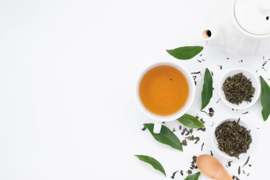 Le thé vert fait-il vraiment maigrir? L’effet reste limité Top view of cup of hot tea near spilled dry green brew and fresh leaves with ceramic teapot
