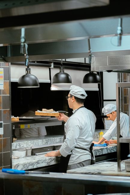 Two chefs working diligently in a contemporary restaurant kitchen setting.