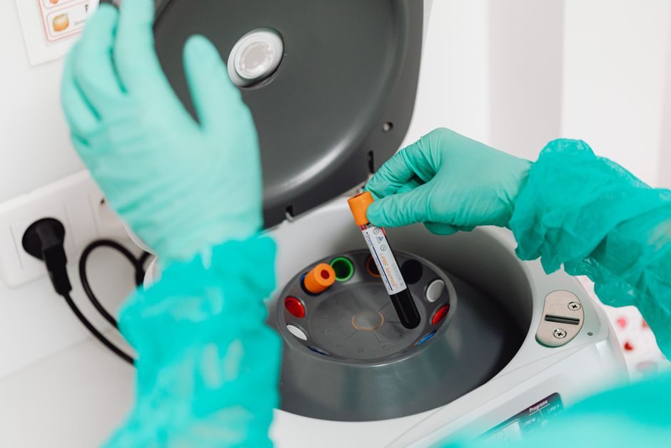 Des nanoplastiques ont-ils déjà été retrouvés dans le sang humain? A lab technician wearing gloves uses a centrifuge for blood analysis in a modern laboratory setting.