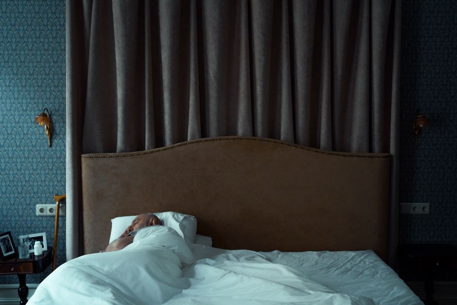 La dette de sommeil peut-elle vraiment tuer? A serene bedroom with a man sleeping, evoking a sense of tranquility and comfort.