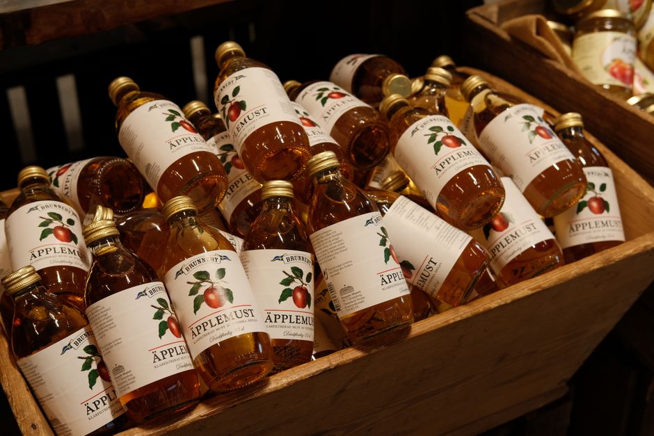 Le vinaigre de cidre fait-il perdre du poids? A variety of bottled apple juice arranged in a wooden crate, perfect for market displays.