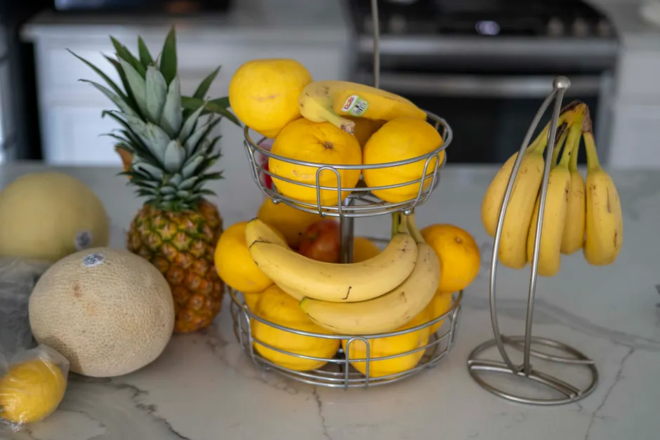 Les bananes sont-elles vraiment radioactives? A variety of fresh fruits including pineapples, bananas, and lemons on a modern kitchen counter.
