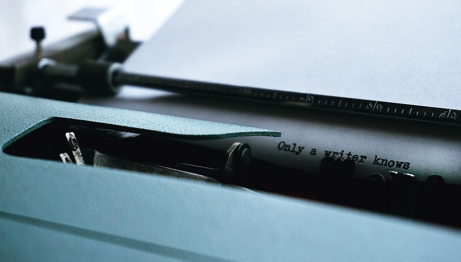 Retro typewriter typing on paper with the text 'Only a writer knows.'