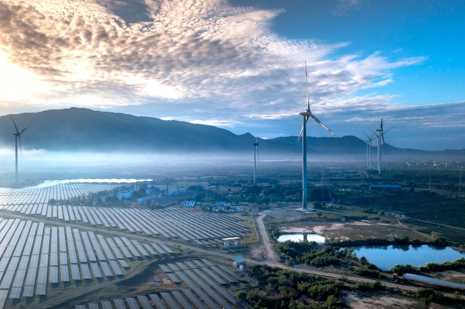 Le monde pourrait-il fonctionner uniquement avec des énergies renouvelables? Stunning aerial view of wind turbines and solar panels in a landscape, showcasing renewable energy technologies.