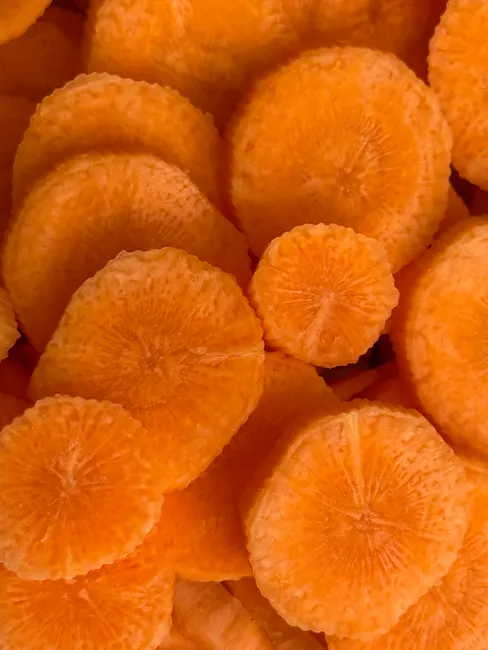 Vibrant orange carrot slices creating a textured pattern.