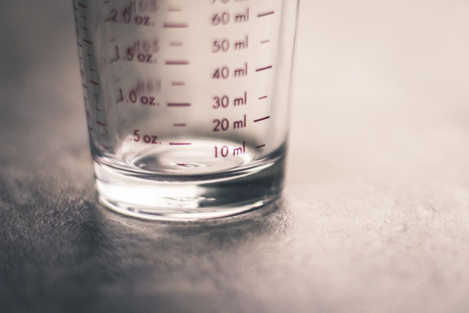 Boire huit verres d’eau par jour est-il vraiment indispensable? An artistic view of an empty measuring glass highlighting metric and ounce measurements.